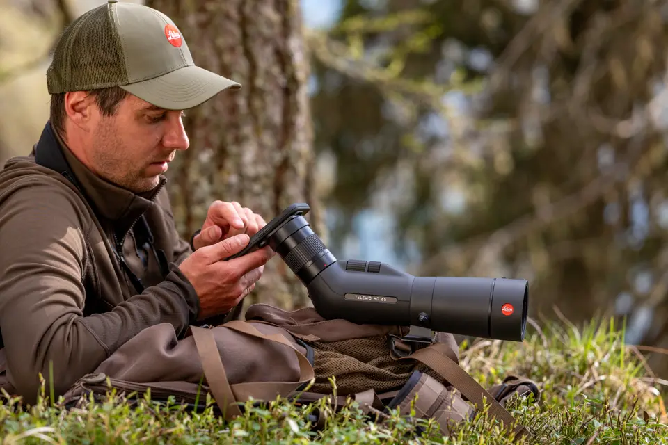 Man is digiscoping with his Televid spotting scope and smartphone