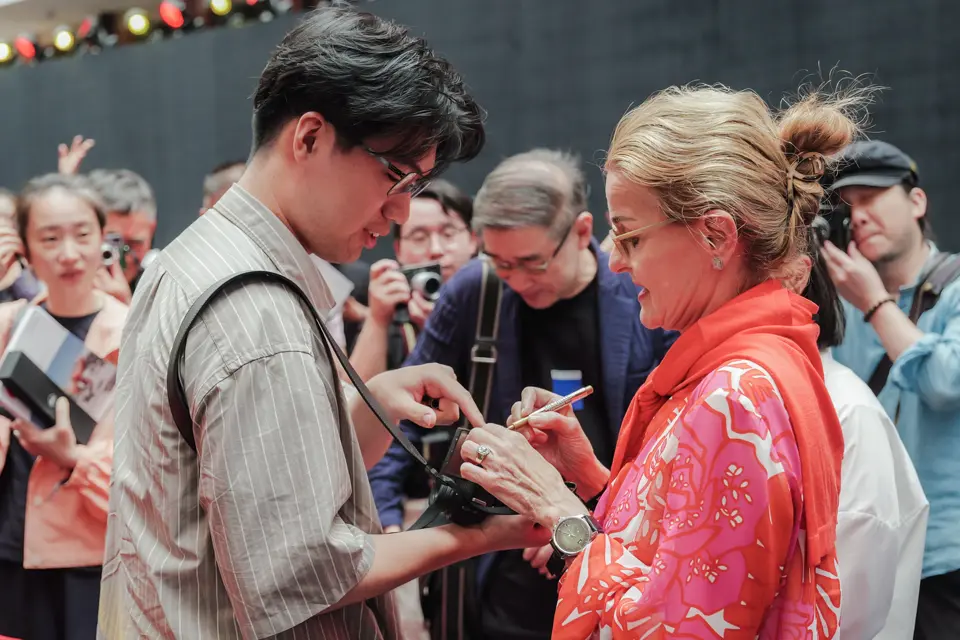 Niu Tong getting his camera signed by Karin Rehn-Kaufmann