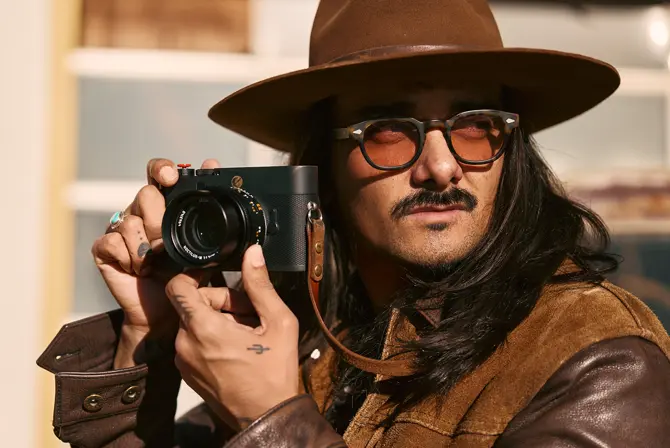 Portrait of Cameron Mackey with camera in hands