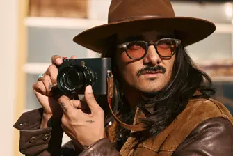 Portrait of Cameron Mackey with camera in hands