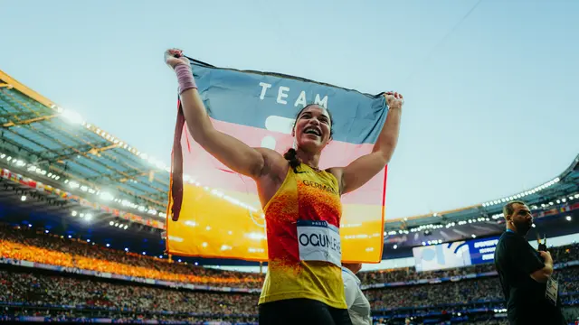 Olympia winner runs with flag.