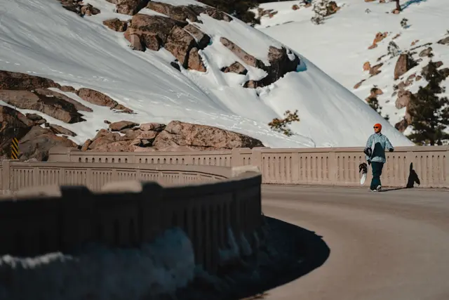 Snowboarder crosses a bridge
