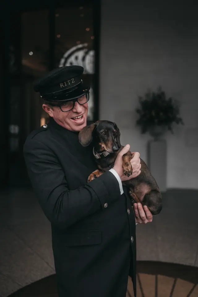 Concierge with a dachshund on his arm