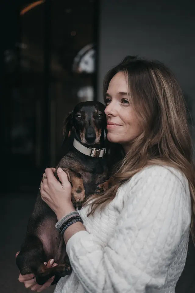 Woman with a dachshund on her arm
