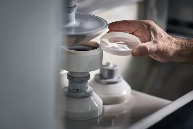 A Leica employee polishes lenses of a Leica spotting scope