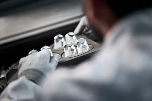 A Leica employee is cleaning the prisms of a Leica spotting scope