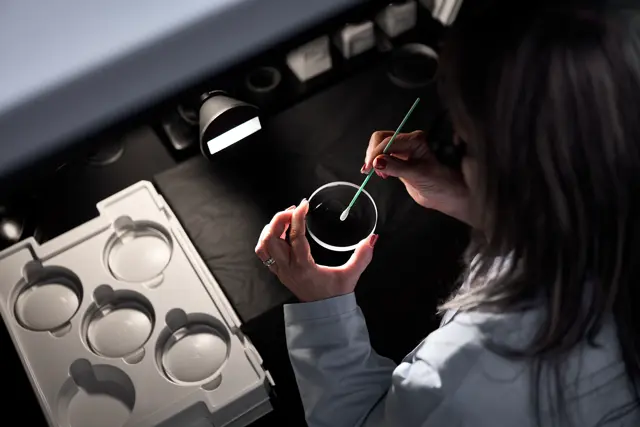 A Leica employee is cleaning the lenses of a Leica spotting scope