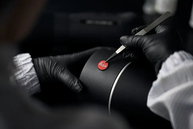 A Leica employee is sticking a Leica logo on the Leica spotting scope