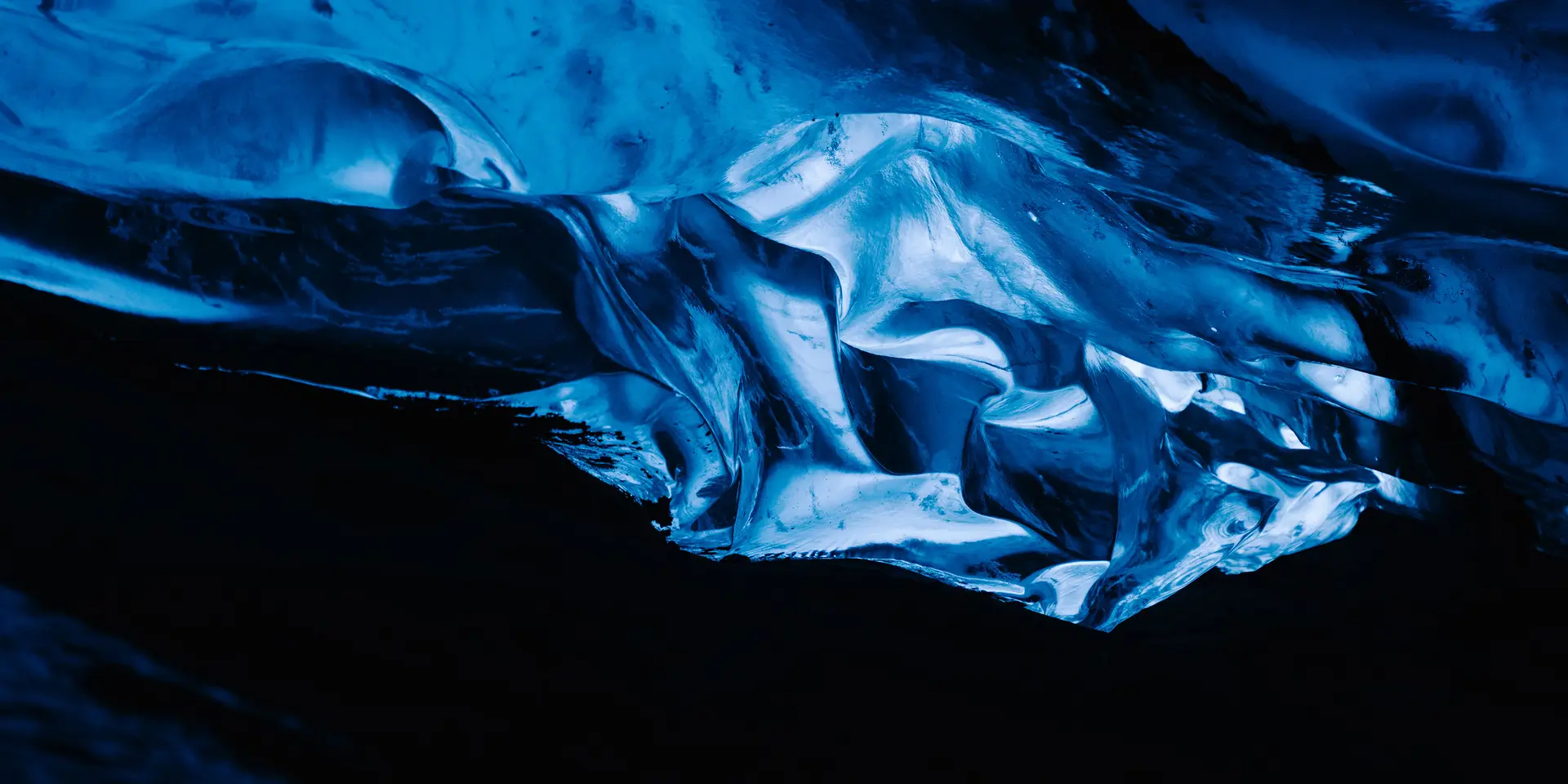 A glowing blue ice formation in a dark cave.