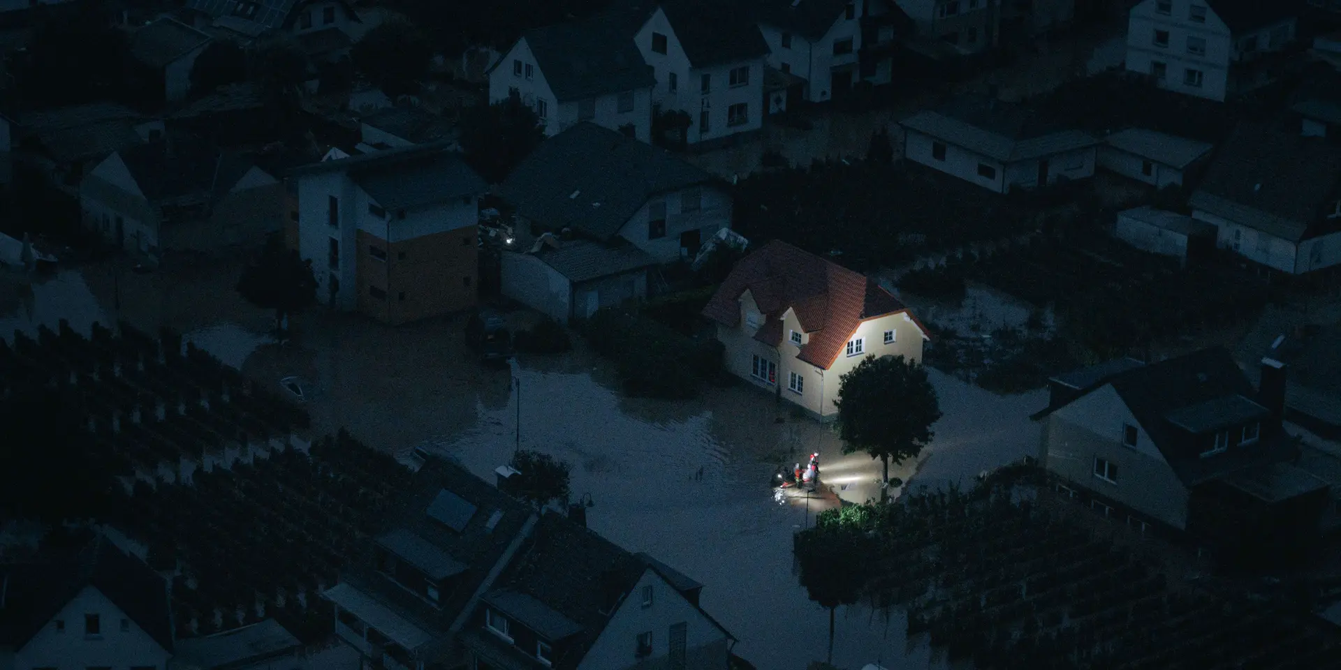 Night shot of a flooded city and rescue workers are in focus.