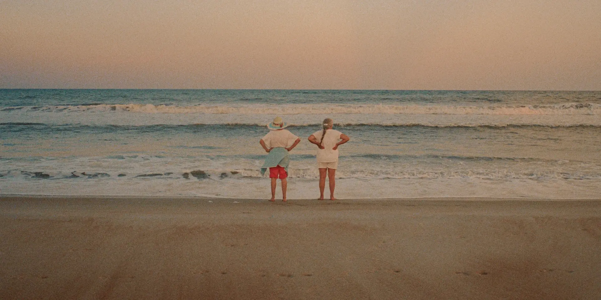 Couple standing on the beach and looking out to sea