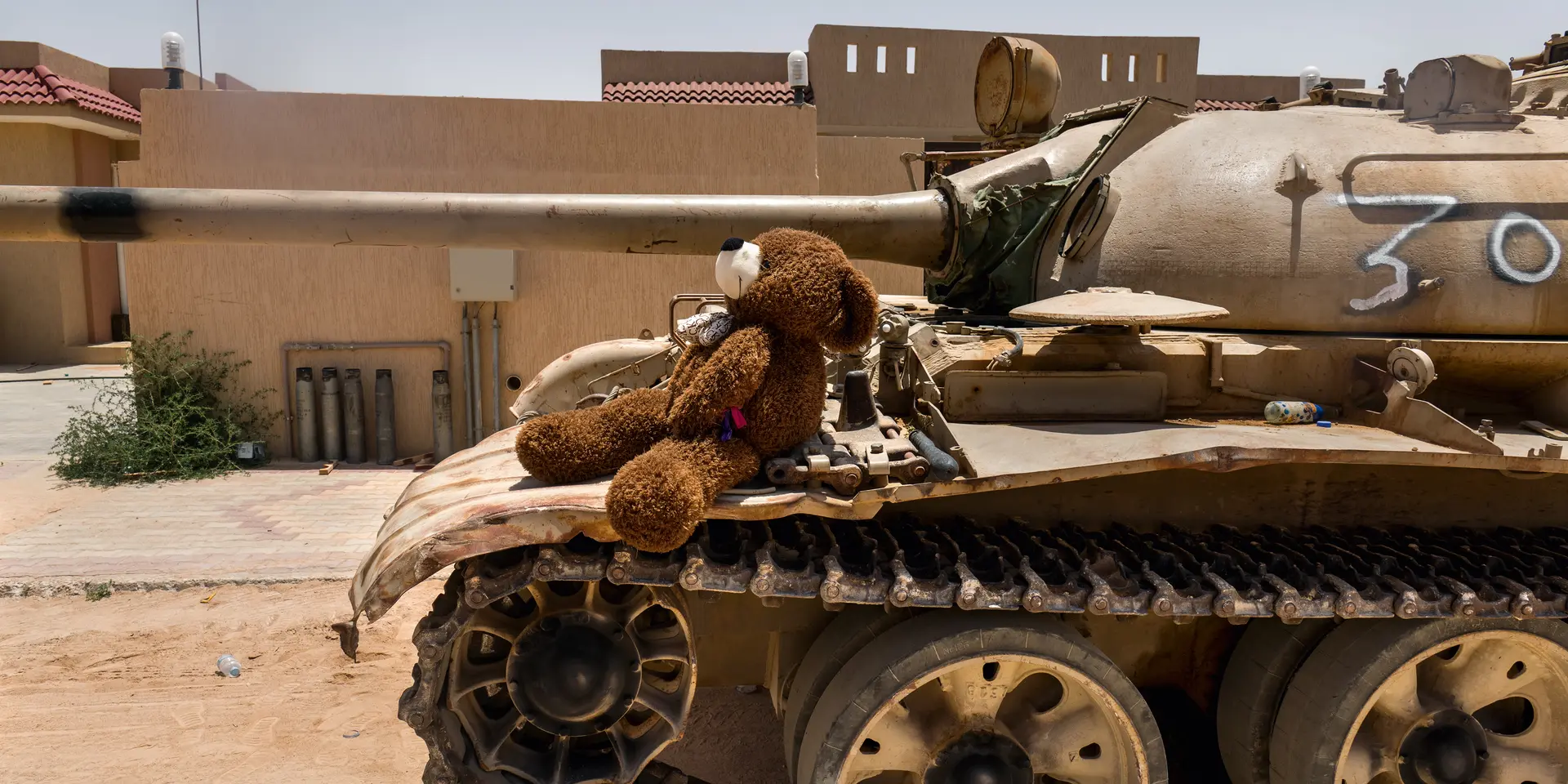Teddy bear sitting on a tank
