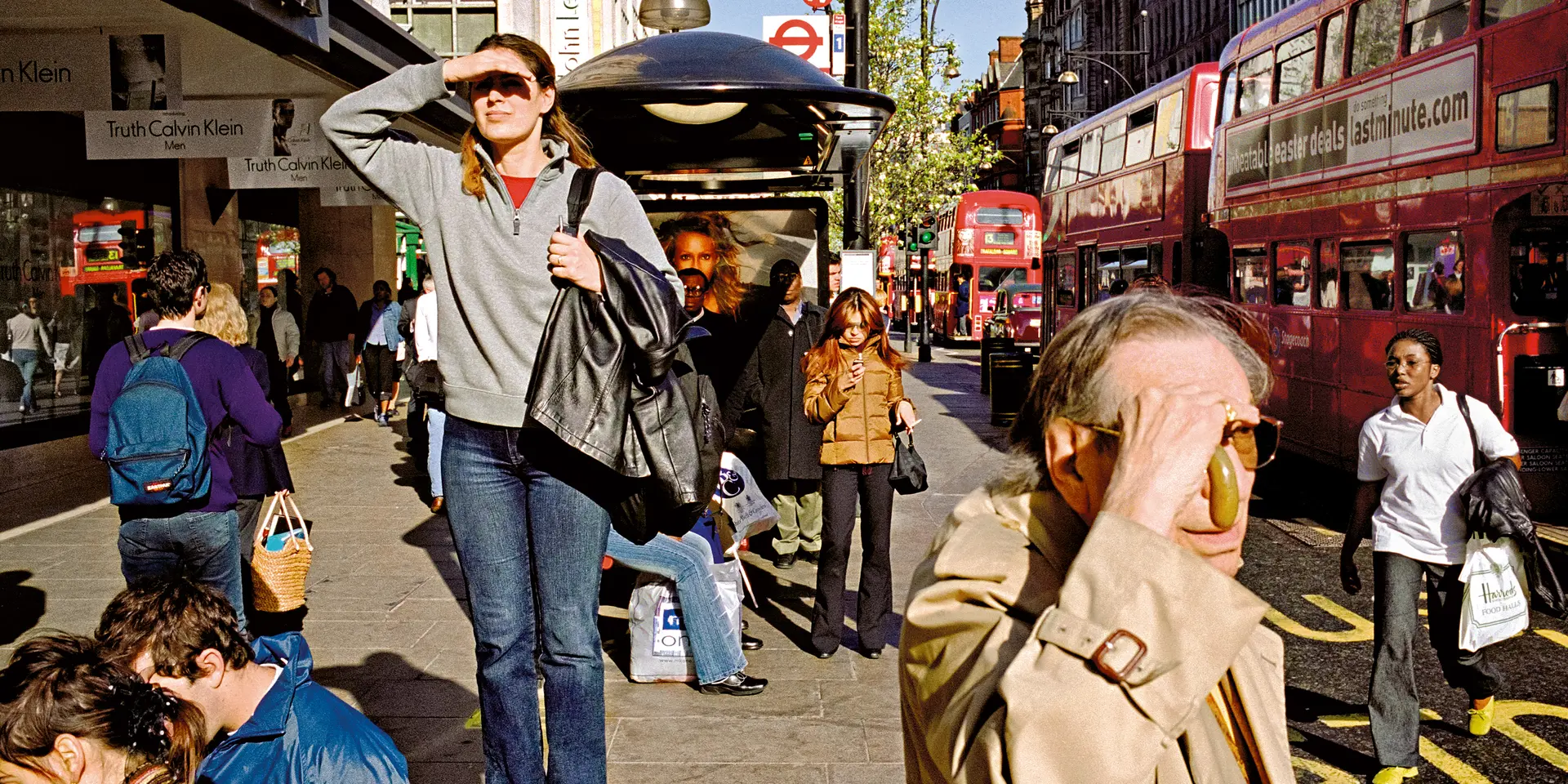 A woman who was standing on a bench, appearing to be looking for something and other people