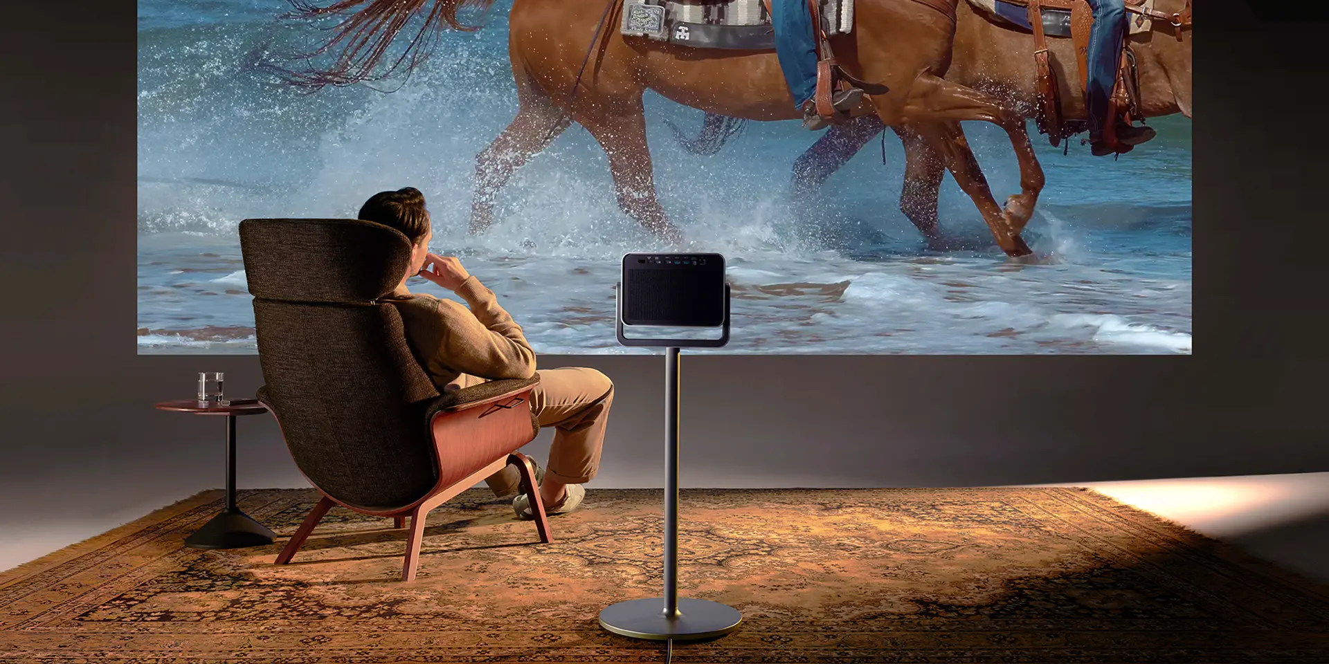 A man is sitting in front of a screen watching a Leica Cine Play 1 projection.