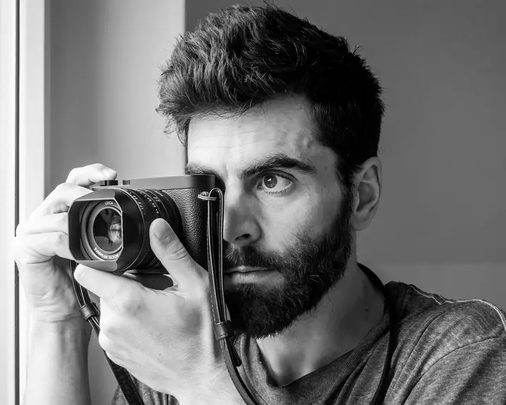 Close-up of a Philipp Weinmann taking a picture with a Leica camera.