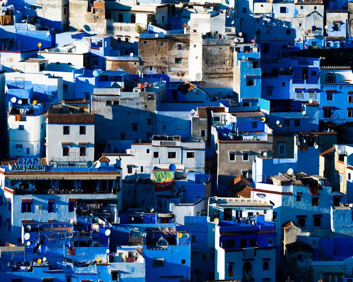 A cityscape with many blue and white houses standing close together.