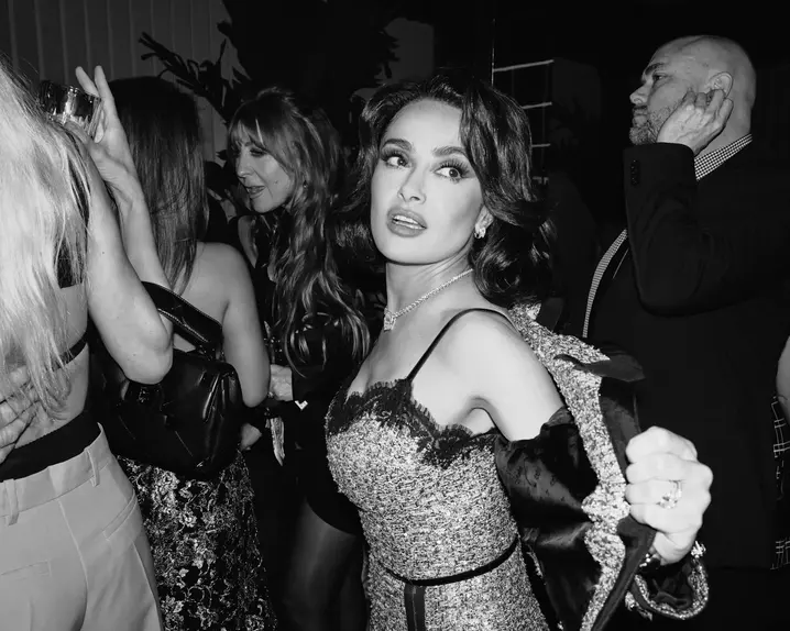 Salma Hayek on a Party surrounded by people in elegant clothes.