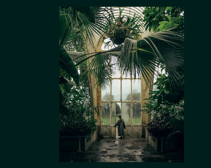 A woman in a tropical house opens a large glass door.