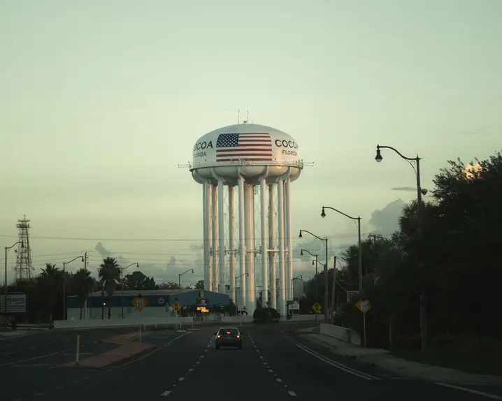 An empty road leads to a water tower labelled ‘Cocoa, Florida’.