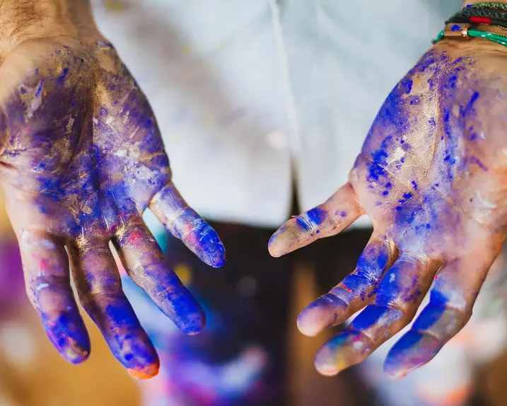 Close-up of hands smeared with blue paint.