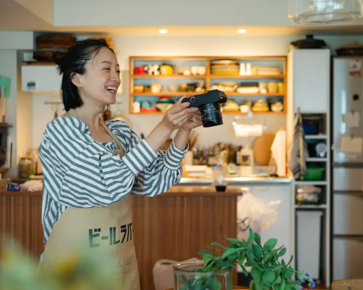Smiling woman taking a picture of a plant in a food store.