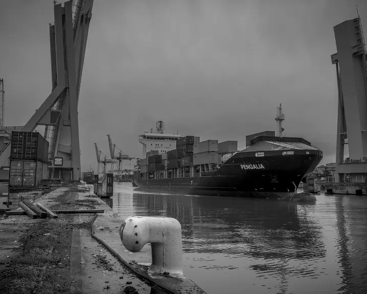 Container ship in the harbour, surrounded by cranes and containers