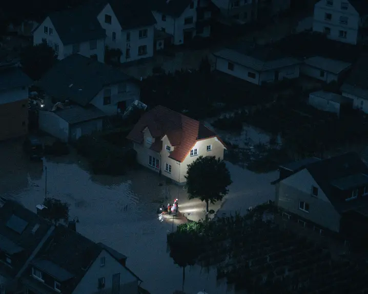 Night shot of a flooded city and rescue workers are in focus.