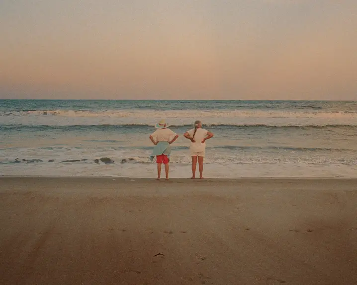 Couple standing on the beach and looking out to sea