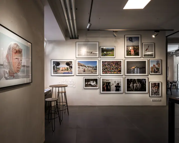 View of a wall with framed photos of people and animals.