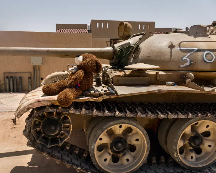 Teddy bear sitting on a tank