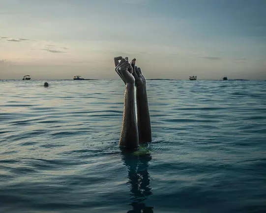 Women's arms peek out of the sea