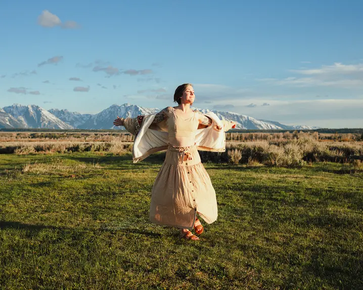 Happy woman with white dress on a meadow