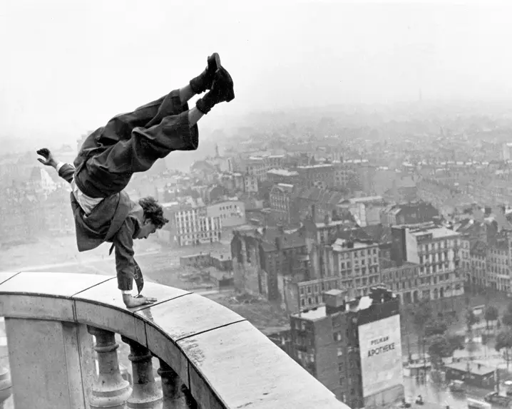 Man doing a handstand on a high banister
