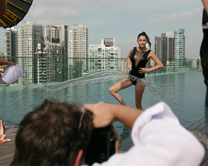 Female model is photographed in Singapore in front of water.
