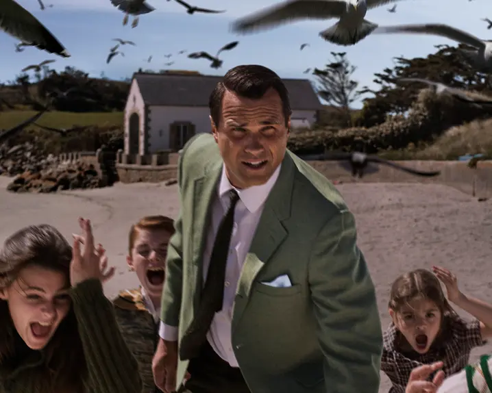A man and five kids running away from crows 