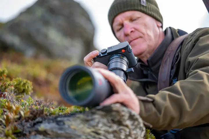 Man is digiscoping with his Leica Televid and Leica Q camera