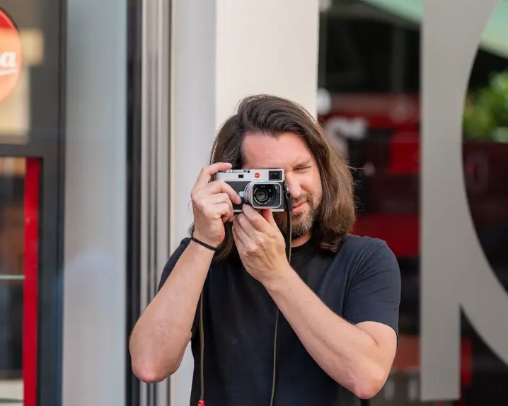 One sales associate standing infront the Leica Store Stuttgart and taking pictures with a Leica M