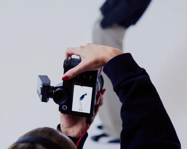 Photographer from behind in a photo studio photographing a man