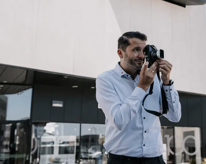 Store Manager of the Leica Store Wetzlar Leitz-Park standing in front of the store and taking pictures with a Leica M