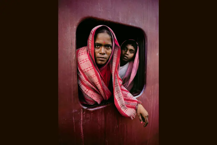 Woman and child with headgear looking through an opening