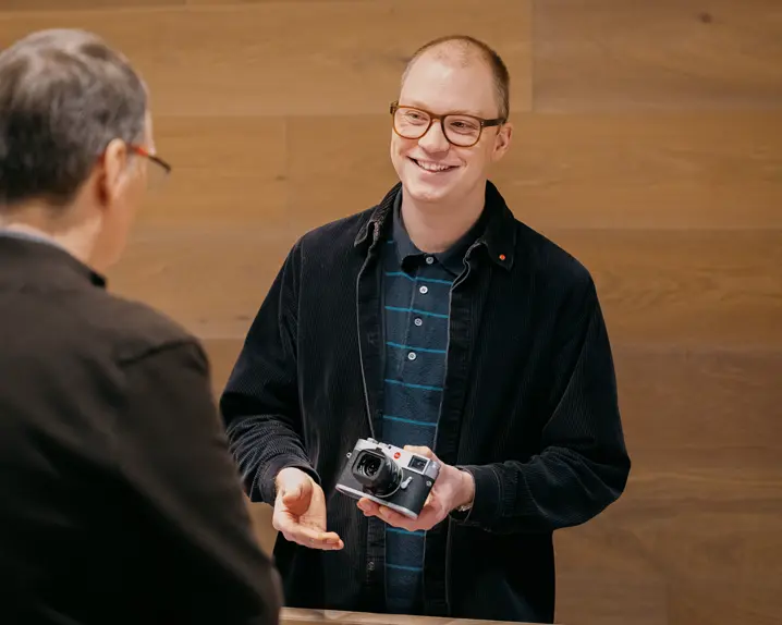 Leica Expert showing a Leica camera and explaining something