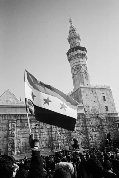 Syria after the fall of the regime in 2024. Many people standing together in front of old ruins