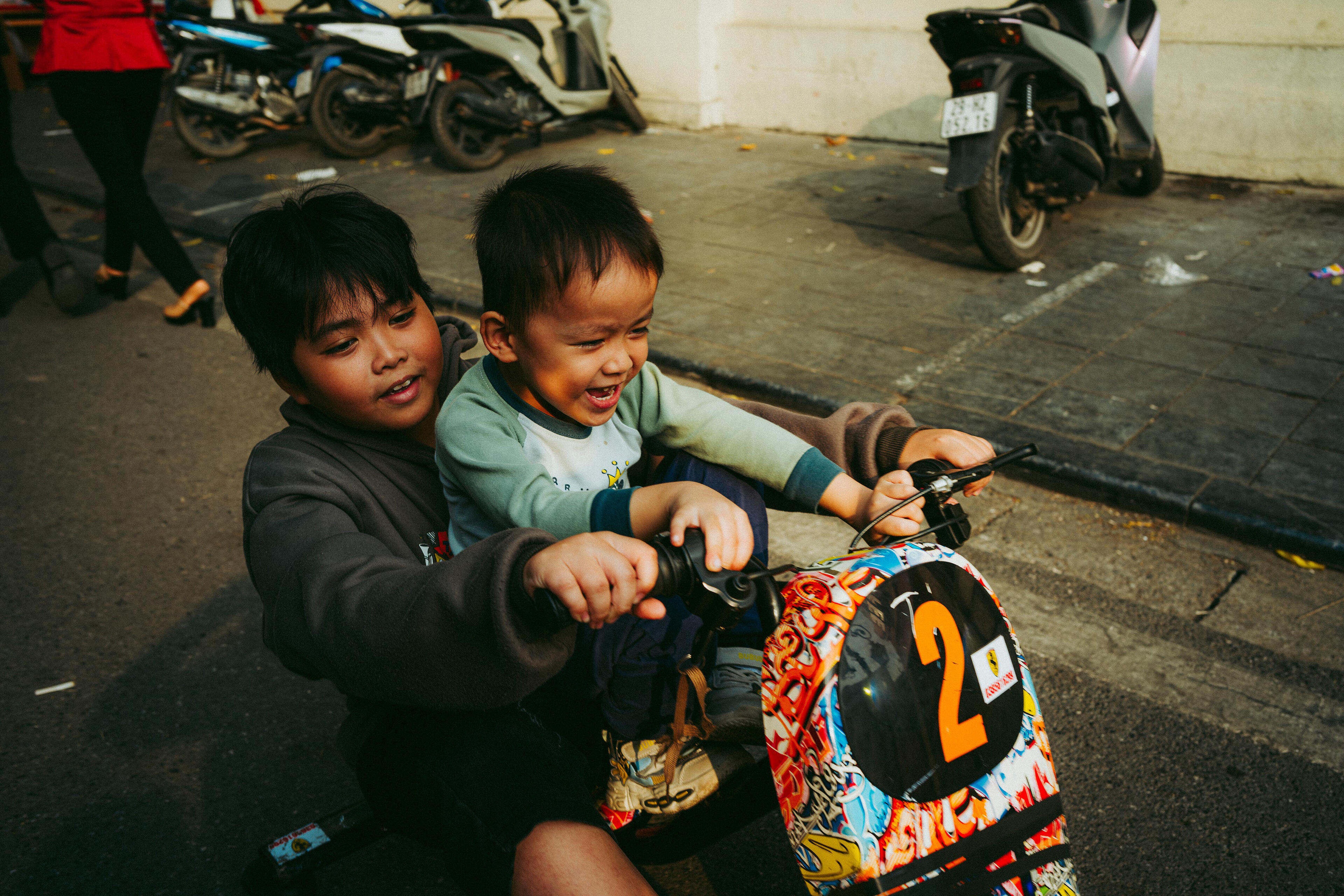 Two boys on a tricycle