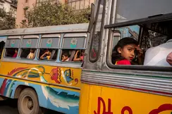 Girl sits in a colorful bus