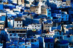 A cityscape with many blue and white houses standing close together.