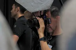 Close-up of a man taking a picture in a studio.