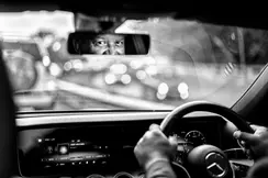 Photo of a car driver looking intently in the rear-view mirror