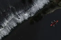 Red canoe paddling along the black sea coast.
