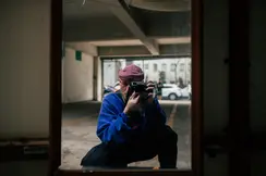 A man takes a picture of himself in a mirror in a garage.