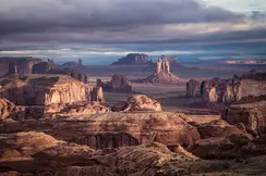 Vast desert landscape with remarkable rock formations under a cloudy sky.